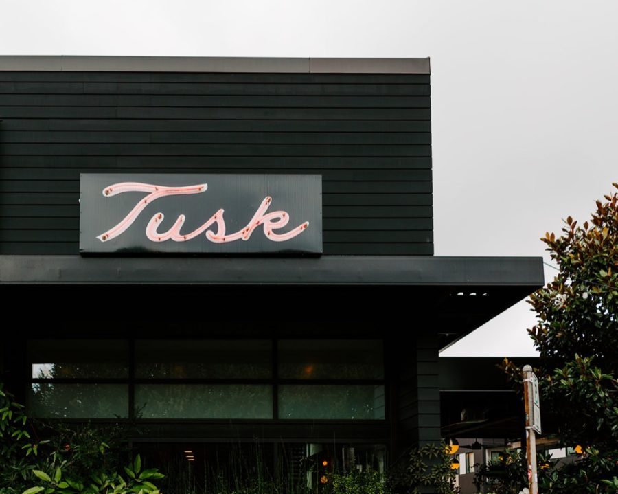 exterior of black building with Tusk written in neon lights