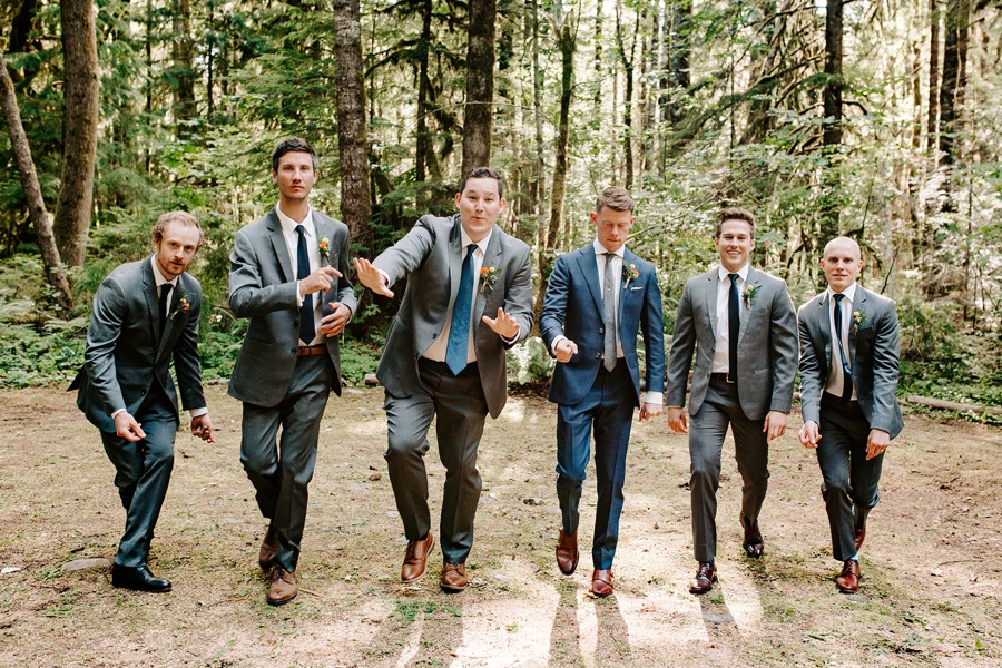 groom and groomsmen dancing in forest