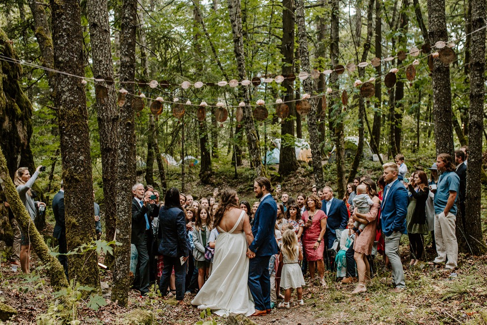 small wedding ceremony in forest with patio lights overhead