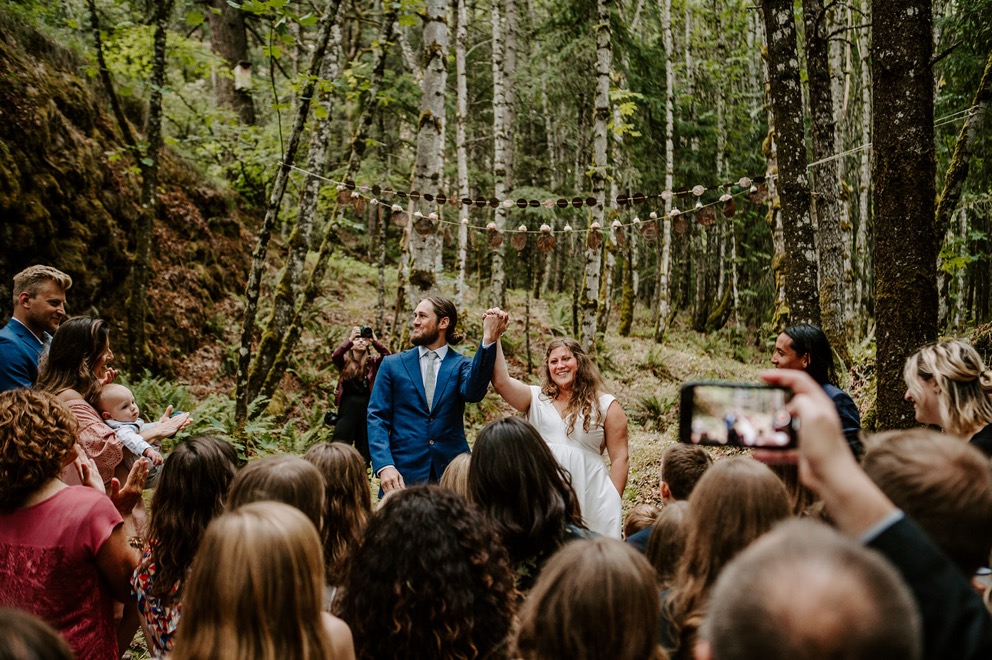 small wedding ceremony in forest with patio lights overhead
