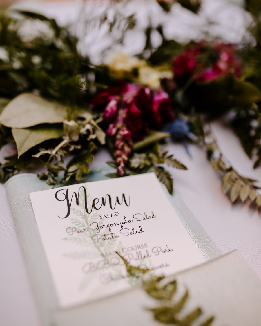 bouquets and dinner menu laid out on wedding table 