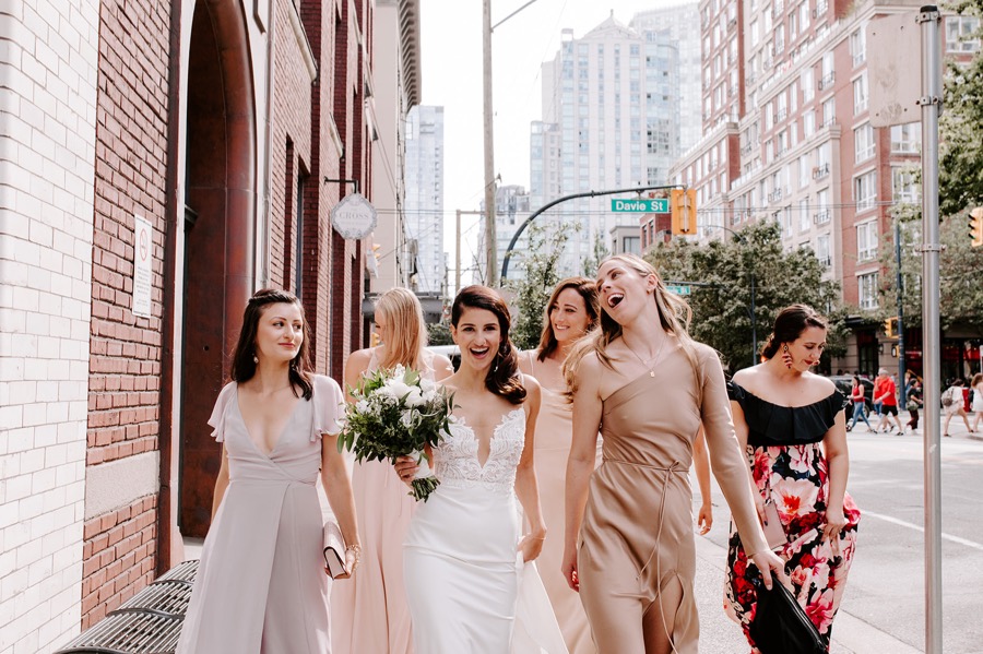 bridesmaids walking and laughing in urban downtown space
