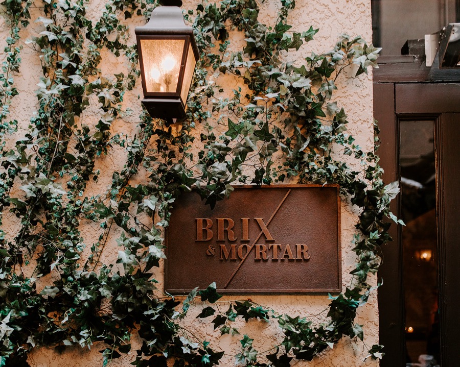 vine covered wall with copper Brix and Mortar sign