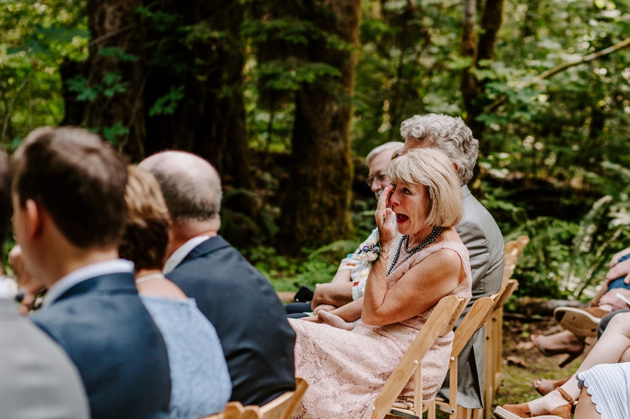 guests wiping tears away during intimate forest wedding