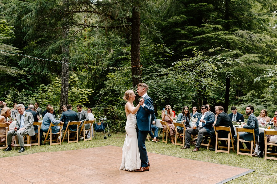 bride and groom first dance under string lights at Oregon forest wedding