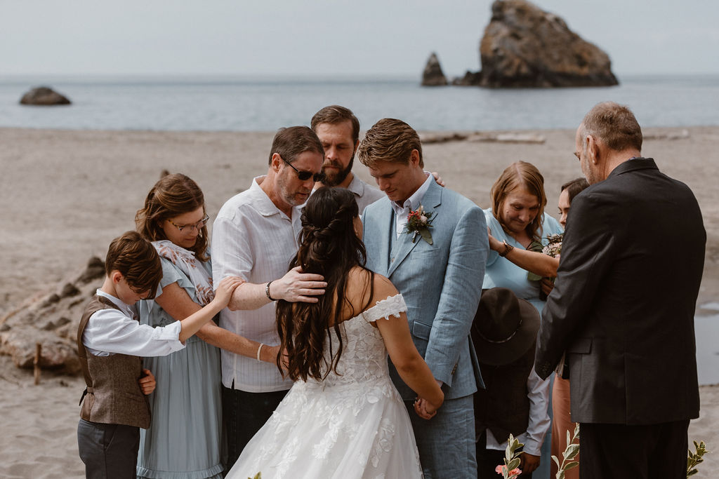 a moment of prayer at an elopement ceremony at Harris Beach